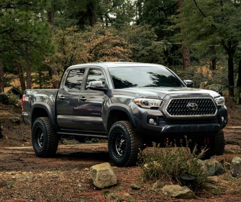 A robust truck stands in a tranquil forest setting, perfect for outdoor adventures.